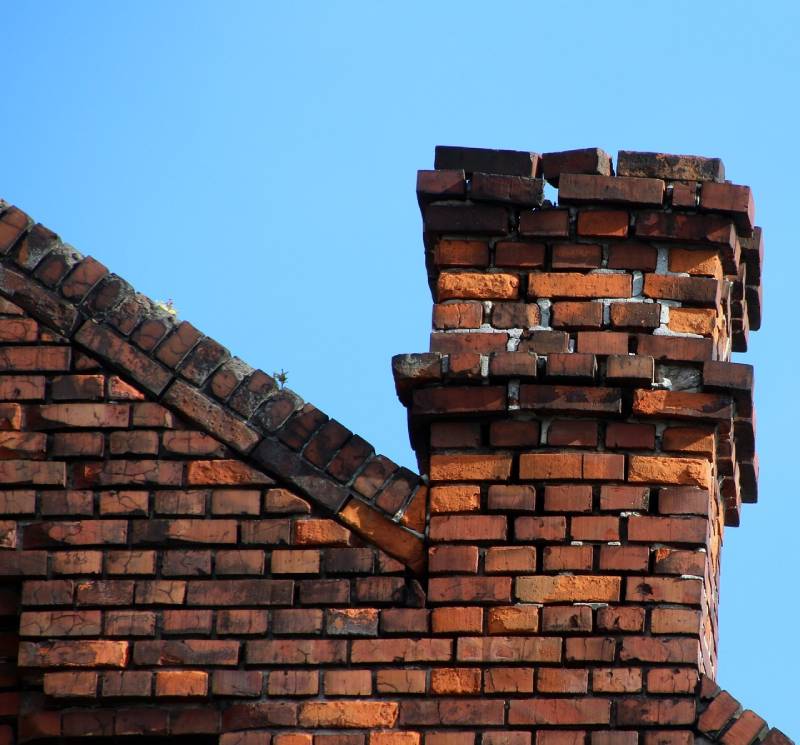 Damaged chimney on an Country Club home showing cracks and missing mortar